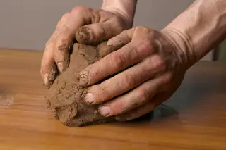 Manos modelando arcilla natural en un espacio de creación libre
